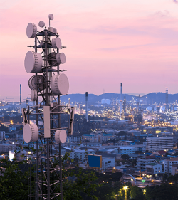 Telekommunikationsturm mit 5G-Mobilfunknetzantenne auf industriellem Hintergrund (C) Shutterstock, Suwin